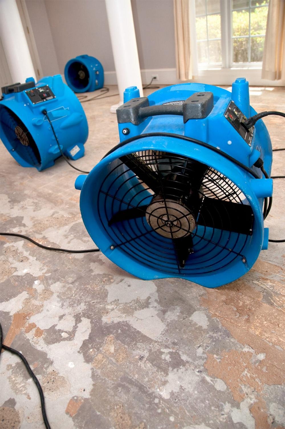 Professional drying fans restoring a room after water damage