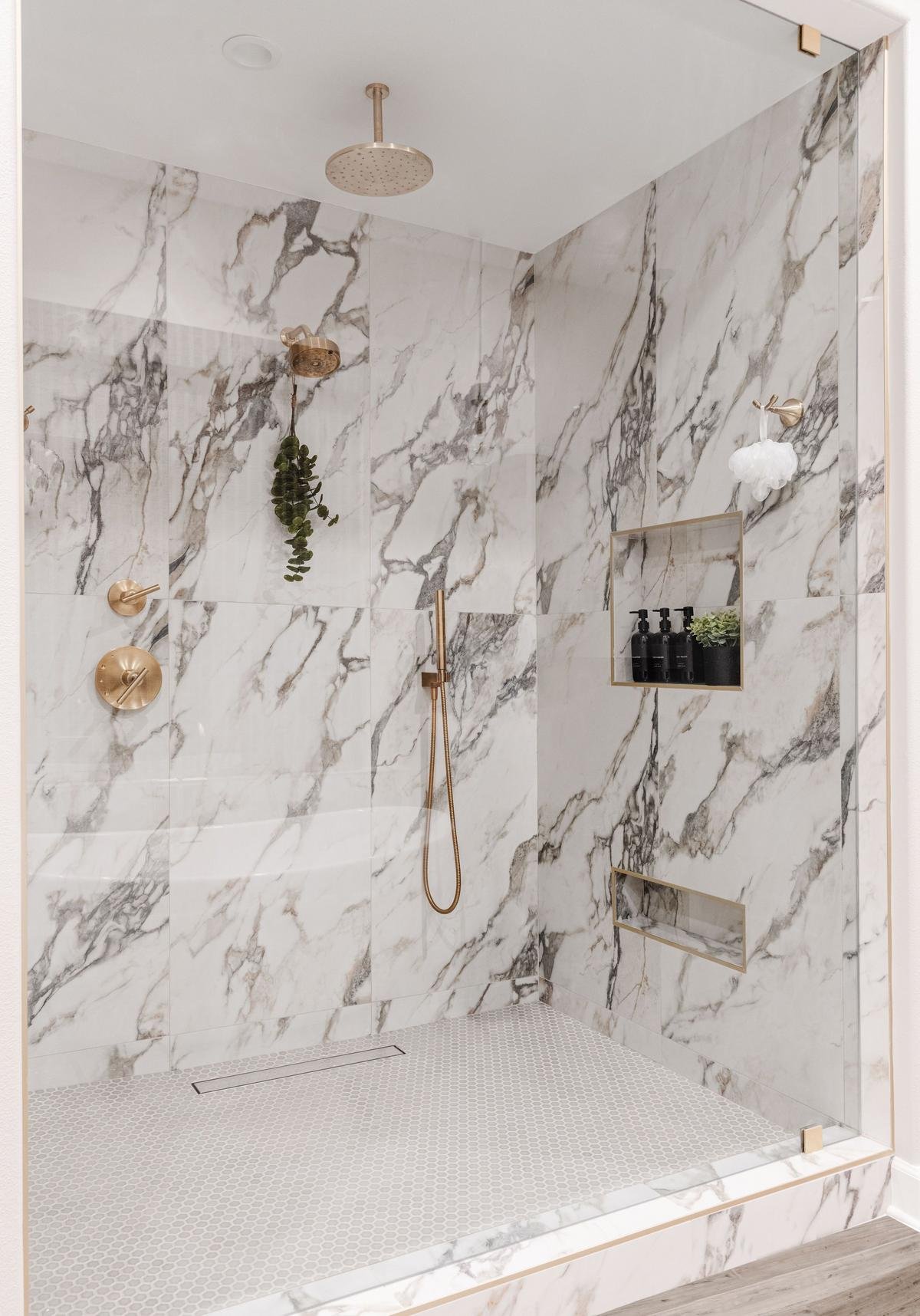 Marble walk-in shower with brushed gold fixtures